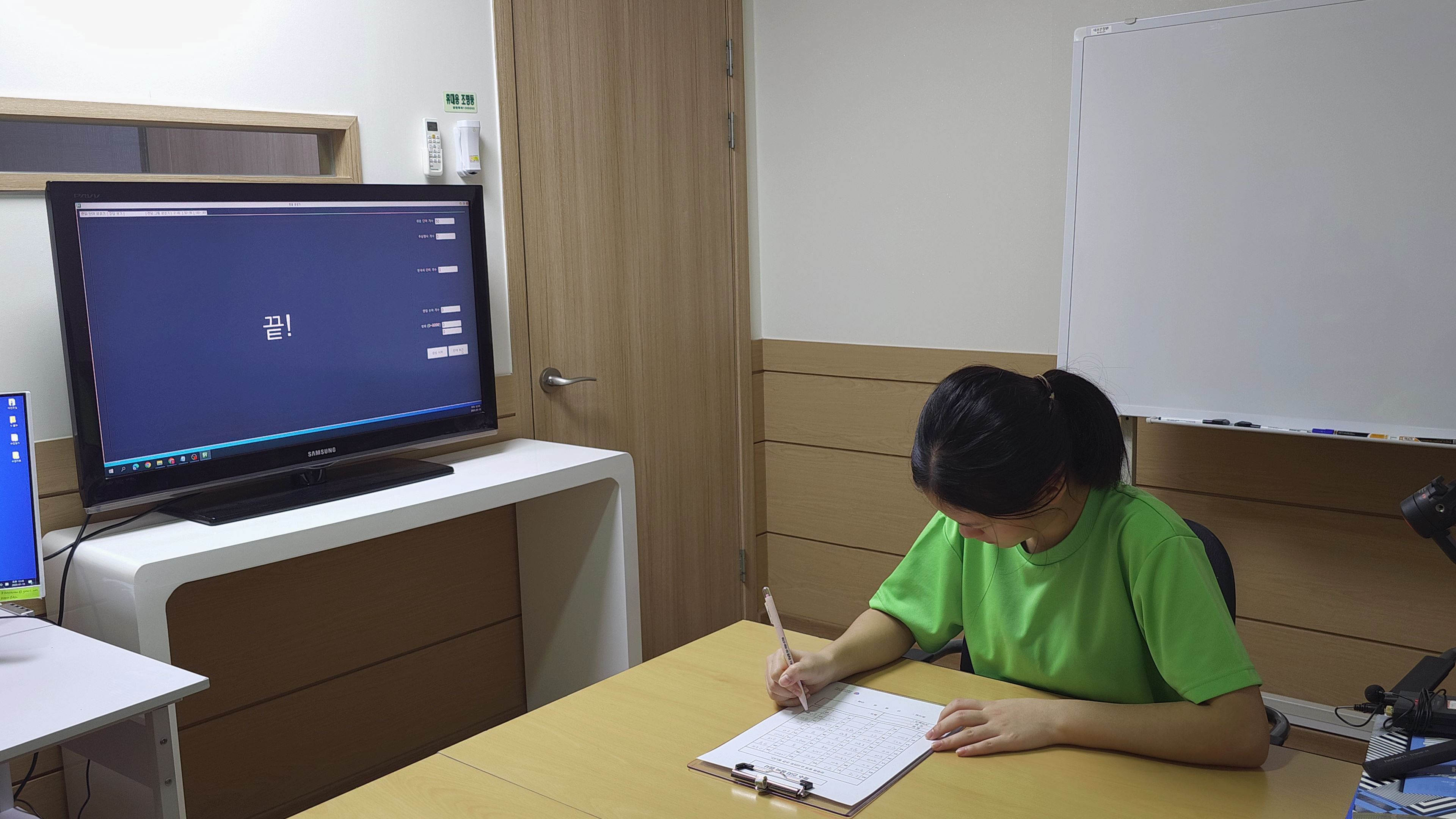 두비전 기존 단어 활동에서 학생이 책상 위에 기록하는 장면. 화면과 기록 자료를 함께 사용하는 환경을 볼 수 있습니다.